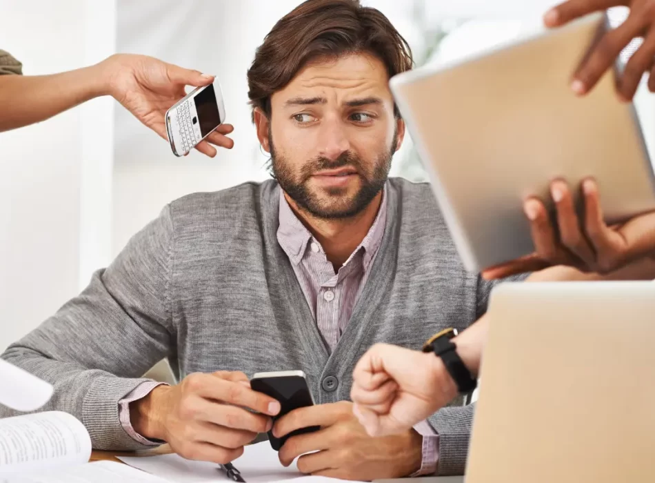 a man sitting at a table with a tablet and cellphone