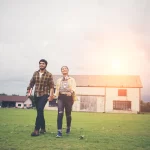 Two students walking in a field.