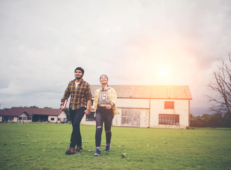 Two students walking in a field.